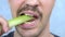 Closeup mouth. handsome mustachioed man happily eats a stalk of celery