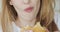 Closeup mouth of young woman biting and chewing burger.