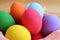 Closeup Multi-colored Easter Eggs in a Basket on Wooden Background