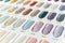 Closeup of a nail color display chart with various glittery nail choices with a numbered code. At a nail salon or spa