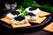 Closeup of natural black caviar served on crackers on black background, texture of fresh sturgeon caviar macro photo.