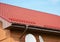 Closeup on new rain gutter system and roof protection from snow board. Red Roofing Construction.