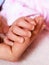 Closeup newborn baby holding his mothers finger