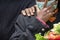 Closeup of a Nigerian woman mourning, holding flowers and wearing a mask