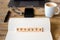 Closeup on notebook over wood table background, focus on wooden blocks with letters making Goodbye word