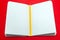 Closeup notepad and yellow pencil with blank sheets white paper on red background. Concept free space, copyspace, business book,