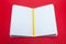 Closeup notepad and yellow pencil with blank sheets white paper on red background. Concept free space, copyspace, business book,