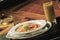 Closeup of oatmeal with strawberries and kiwis on a piano with a glass of green juice on it