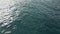 Closeup ocean swell surface reflecting sun beams. Drone view calm sea rippling