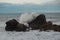 Closeup of the ocean waves and sea foams in a big rock