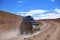 Closeup of an off road vehicle running in the dusty trail. Adventure in Bolivia highlands in the Andes.