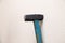 Closeup of old black iron hammer with shabby blue wooden handle stuck into a white wall. Ð¡oncept of repair, reconstruction,