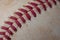 Closeup of old, dirty baseball with red seams