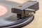 Closeup of old and dusty vinyl record player with arm and needle in focus