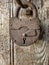 Closeup old padlock on a dilapidated wooden door