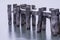 Closeup of old pier posts broken and standing in calm water, wee