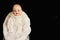 Closeup of old porcelain child doll with blue eyes on black background