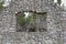 Closeup of old stone ruins of a forgotten lodge surrounded by greenery