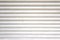 closeup old white metal roller shutter door, horizontal lines abstract background