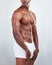 Closeup of one African American fitness model posing topless in a underwear and looking muscular. Confident black male