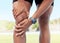 Closeup of one man holding sore knee from exercising outdoors. Uncomfortable athlete suffering with painful leg injury