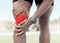 Closeup of one sportsman holding his sore knee in glowing red. Uncomfortable athlete suffering from a painful leg injury