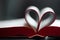 Closeup of an open book, novel with pages bent, shaped into a heart pattern to show the concept of a love to read