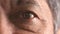 Closeup for optic vision exam of an older man looking for a treatment to improve eyesight at optometrist. Face portrait