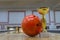 Closeup of orange bowling ball near golden trophy