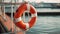 closeup orange inflatable lifebuoy on ship in sunny day