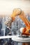 Closeup of Orange Robot Arm with Blurry Cityscape Background. Generative ai