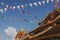 Closeup of an ornate Buddhist temple roof with colorful banners