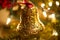 A closeup of an ornate gold bell Christmas ornament.