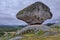 Closeup of outcrops covered in mosses and grass under a cloudy sky in Portugal