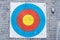 Closeup on outdoor archery target board with arrow on bullseye