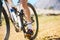 Closeup, outdoor and biker with fitness, cycling and training for a competition, road and sneakers. Zoom, male person or