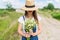 Closeup outdoor portrait of a beautiful young woman in hat. Attractive happy girl in a field with bouquet of flowers