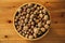 Closeup overhead shot of nuts in a wooden plate on a wooden table