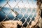 Closeup of a padlock on a barbed wire fence under the sunlight