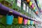 Closeup of pails hanging on taps of perfume bottles on shelves