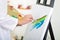 Closeup painters hands using brush on canvas applying colorful art to white background