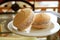 Closeup a Pair of Alfajores, Traditional Latin American Cookies on White Plate Served on the Table