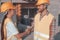 Closeup of a pair of builders shaking hands while standing near the construction site