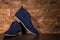 Closeup of Pair of Mens Blue Suede Semi-Brogue Boots Against Wooden Background Indoors