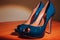 Closeup of a pair of polished blue high heel shoes on the floor