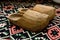 Closeup of a pair of wooden shoes on a beautiful carpet.