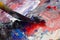 closeup of a palette knife slicing through thick paint blobs