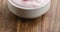 Closeup pan of organic strawberry yogurt on wooden table