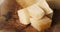 closeup pan of pieces of italian parmesan cheese on wood table