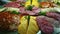 Closeup panorama with assortment of cheese, bacon, salami slices, and greenery